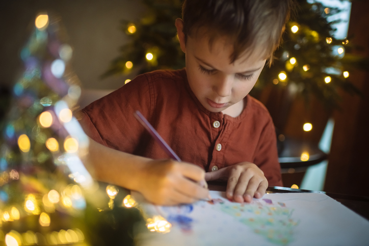 Little boy drawing a picture for mom and dad for Christmas