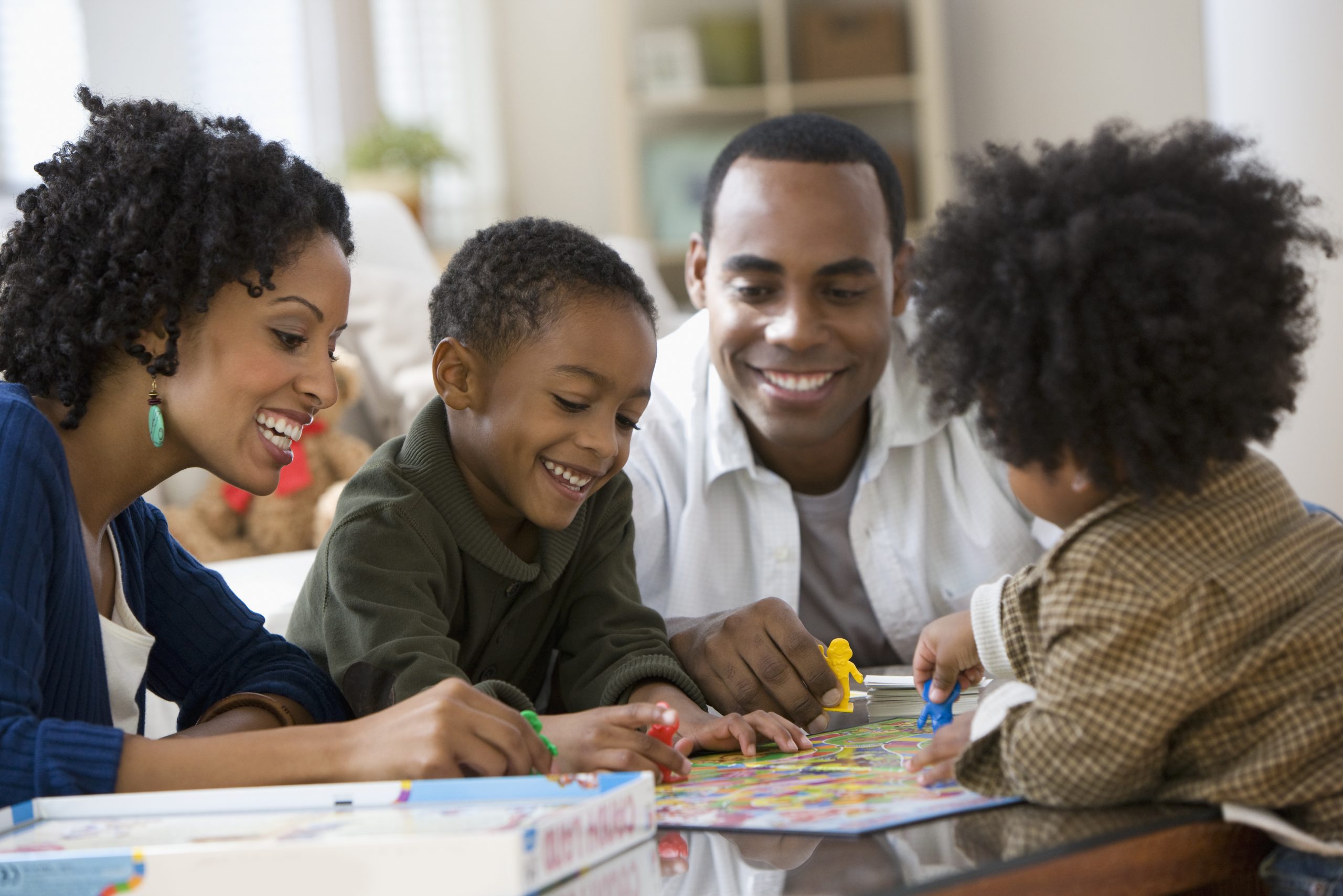 African American family playing board game together