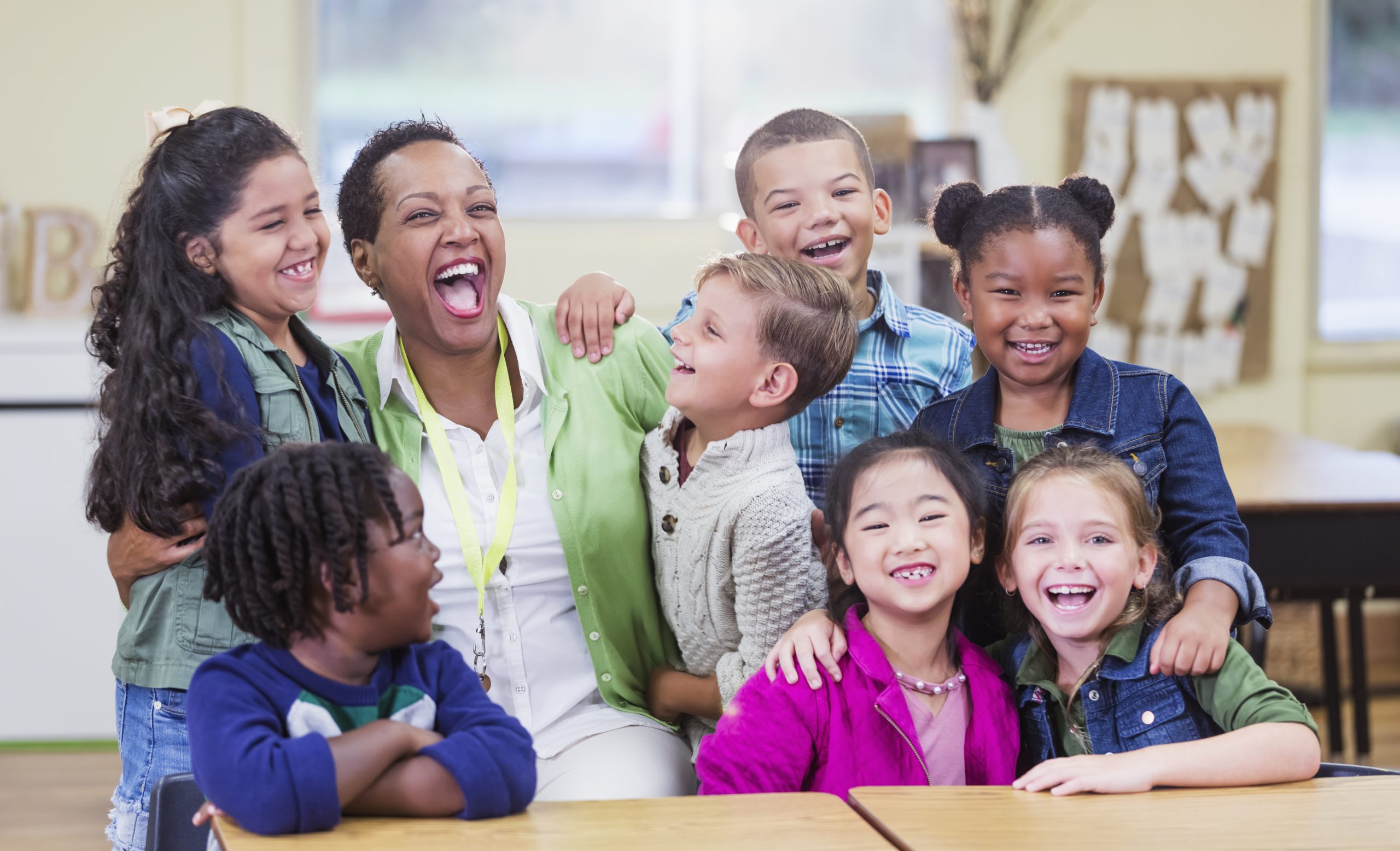 Teacher and elementary school students, fun in classroom