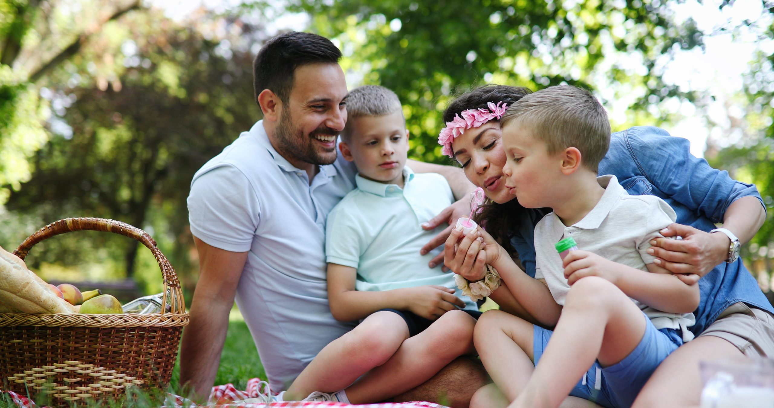 Happy young family enjoying picnic in nature