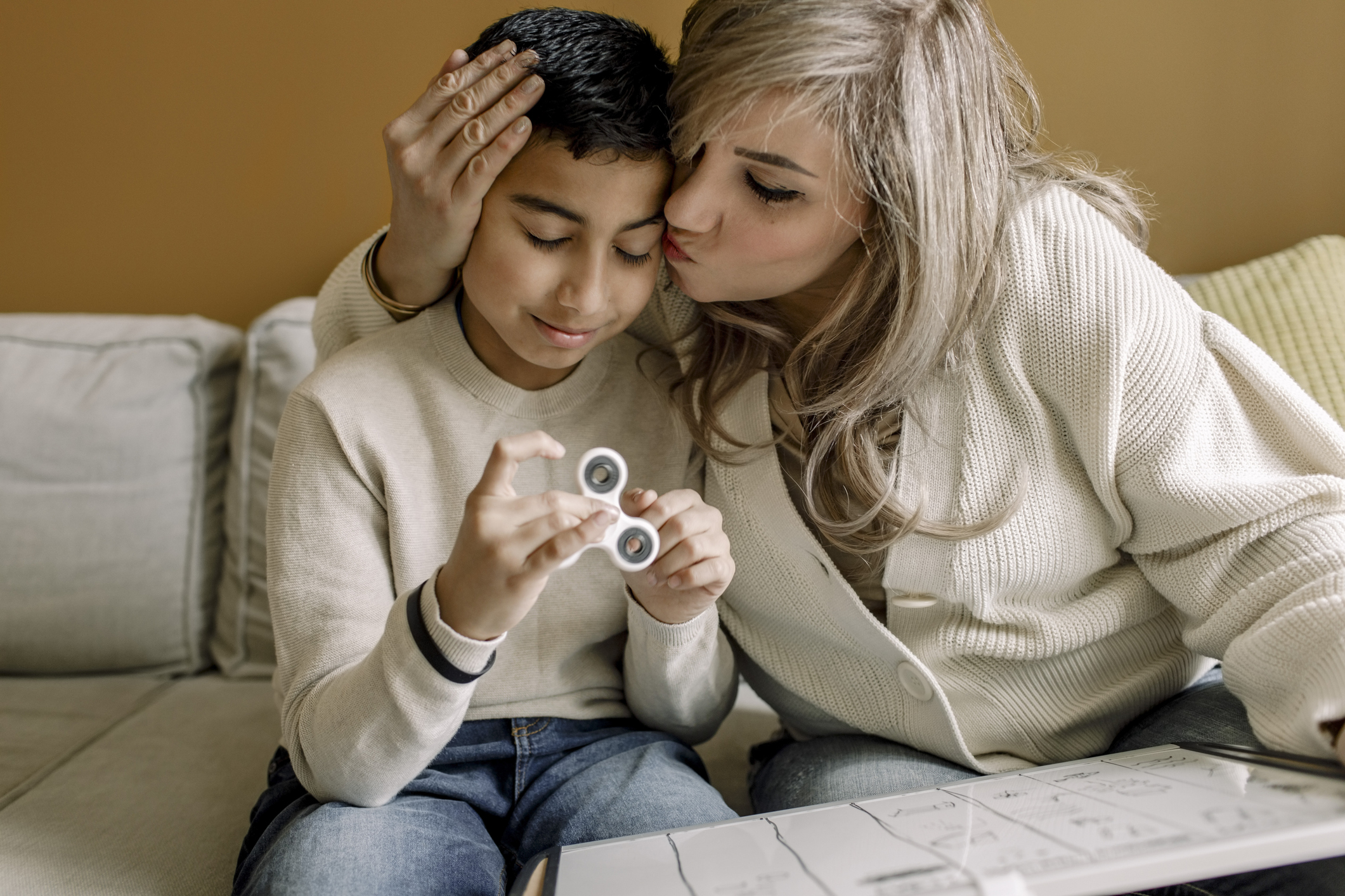 Mother kissing son while teaching at home