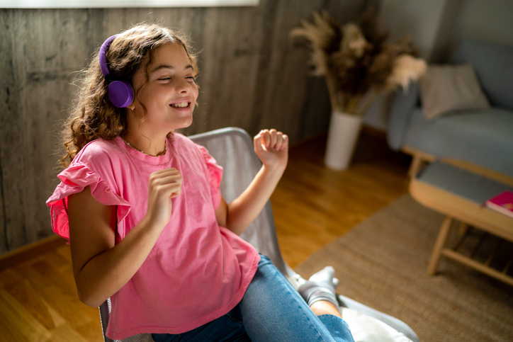 Teenage girl having fun listening a music at home